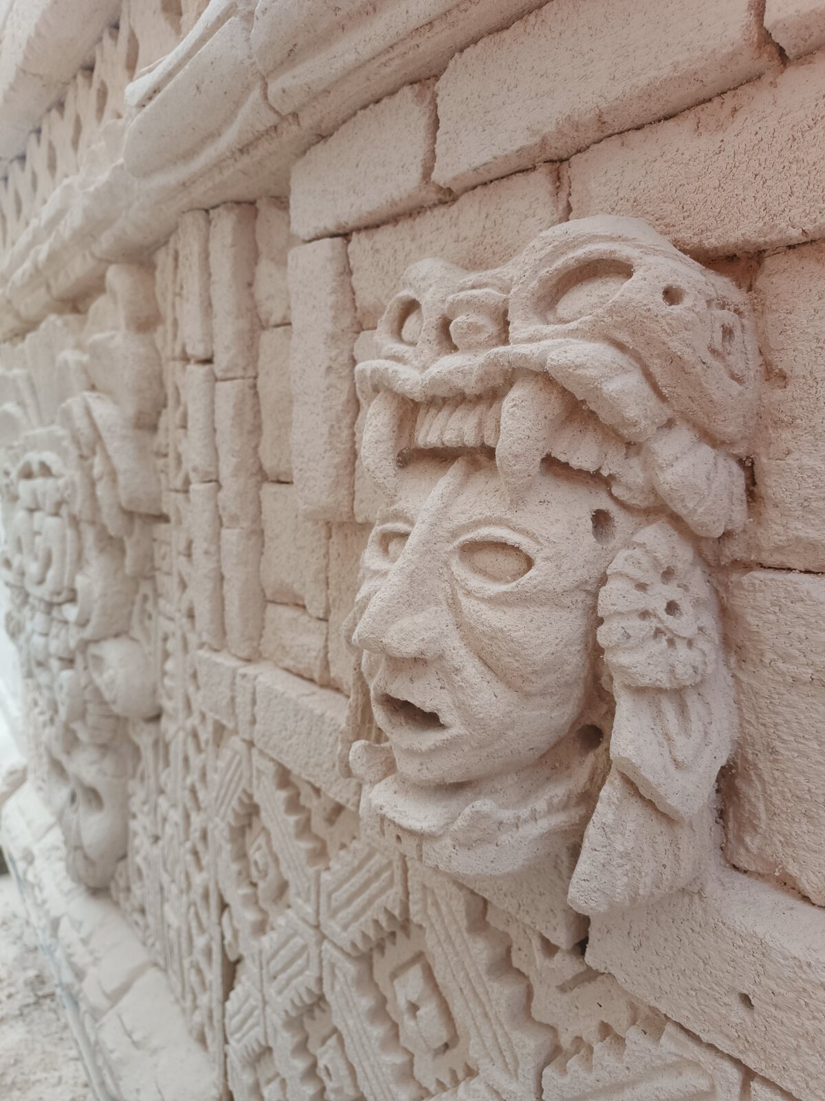 Carved relief featuring a sculpted face surrounded by ornament