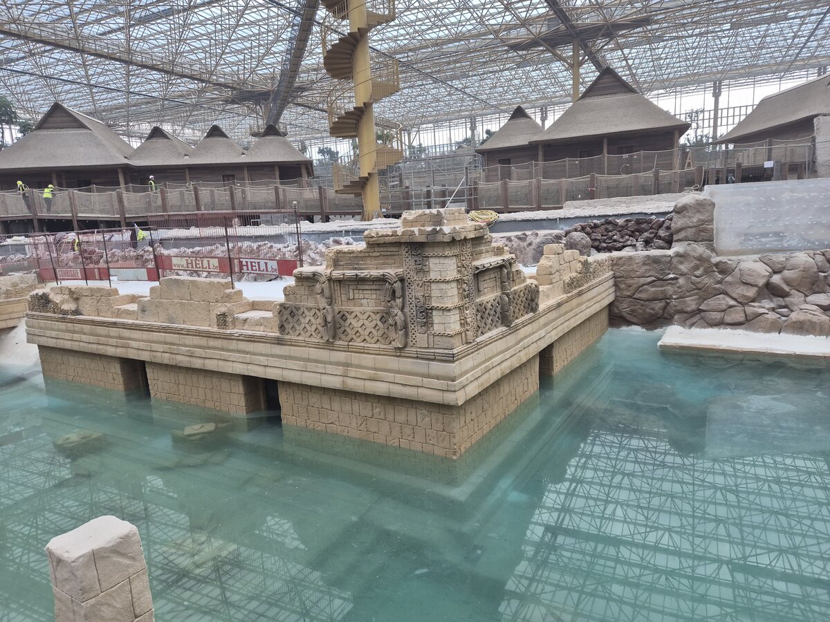 Themed temple structure surrounded by water under a glass roof at Pairi Daiza
